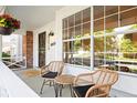 Cozy front porch featuring wicker seating, hanging flowers, and a welcoming 'hello' mat for guests at 8035 S Garfield Way, Centennial, CO 80122