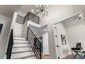 Bright foyer with modern chandelier, and staircase with iron railings leading to the upper level at 10 Summit Ash, Littleton, CO 80127