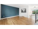 Bright, open living room with hardwood floors and a striking blue accent wall at 325 Mulberry Cir, Broomfield, CO 80020