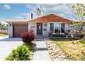 Attractive home with a stone pathway, gray brick facade, and a lush, landscaped front yard at 6045 S Cook St, Centennial, CO 80121