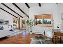 Bright living room boasting high ceilings, exposed beams, hardwood floors, and views of the property at 1340 Deerpath Trl, Franktown, CO 80116