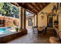 Outdoor dining area with a stone wall, ceiling fan, a waterfall feature and lush landscaping at 45 Charlou Cir, Cherry Hills Village, CO 80111