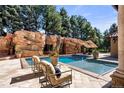 This luxurious pool features a rock waterfall and inviting lounge area with comfortable seating at 45 Charlou Cir, Cherry Hills Village, CO 80111