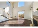 Sun-filled living room with high ceilings, a cozy fireplace, hardwood floors and staircase at 3829 Odessa St, Denver, CO 80249