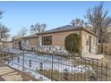 Side view of the house showcasing a landscaped yard and metal fence at 3259 N Adams St, Denver, CO 80205