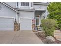 Charming two-story home showcasing a 3-car garage, landscaped yard, and inviting entrance at 10456 Carriage Club Dr, Lone Tree, CO 80124
