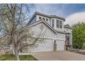 Charming two-story home showcasing a 3-car garage, landscaped yard, and inviting entrance at 10456 Carriage Club Dr, Lone Tree, CO 80124