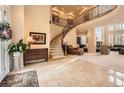 Grand foyer with a curved staircase, tile flooring, and an open view to the living spaces at 10456 Carriage Club Dr, Lone Tree, CO 80124