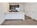 Open kitchen boasts a large center island with quartz countertops, stainless appliances and hard wood floors at 1986 S Haleyville Way, Aurora, CO 80018