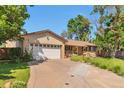 Beautiful front of the house with lush greenery, chairs on the porch, and a two car garage at 8262 Otis Ct, Arvada, CO 80003