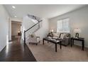 Bright living room with a cozy seating arrangement and staircase, showcasing a modern and inviting atmosphere at 9608 Albion Ln, Thornton, CO 80229