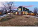 Well-maintained home featuring brick accents, green siding, an attached garage, and a spacious yard at 375 Aspenwood Ct, Lafayette, CO 80026