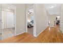 Hallway with hardwood floors leads to a bedroom and a bathroom, showcasing the home's layout at 25811 E Archer Ave, Aurora, CO 80018