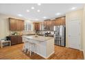 Spacious kitchen boasts granite countertops, a central island, stainless steel appliances, and wood flooring at 25811 E Archer Ave, Aurora, CO 80018