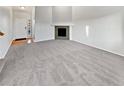 Spacious living room with neutral carpet, a fireplace, and a bright entryway showcasing a clean and modern design at 25952 E 5Th Pl, Aurora, CO 80018