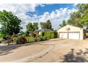 An exterior home view highlighting the large driveway, two-car garage with a basketball hoop and manicured greenery at 1060 S Eaton St, Lakewood, CO 80226
