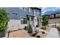Well-maintained two-story home with blue and beige siding, landscaped front yard with seating area, and concrete walkway at 9279 Merino Ct # B, Littleton, CO 80125