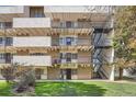 Exterior view of apartments, featuring multiple balconies, stairwell, and well-maintained green spaces at 384 S Ironton St # 201, Aurora, CO 80012