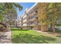 Exterior view of apartments featuring multiple balconies, stairwell, and well-maintained green spaces at 384 S Ironton St # 201, Aurora, CO 80012
