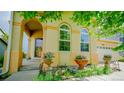 Welcoming entryway featuring an arched porch, decorative planters, and vibrant landscaping at 9832 N Crystal Lake Dr, Littleton, CO 80125