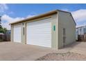 Two-car detached garage with white doors and light green siding at 8481 Uinta St, Commerce City, CO 80022
