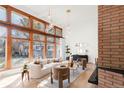 Bright living room featuring floor-to-ceiling windows, modern furniture, and a prominent brick fireplace at 6110 E 6Th Avenue Pkwy, Denver, CO 80220