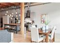 Dining area and kitchen with stainless steel appliances, island with seating, and modern light fixtures at 2955 Inca St # 2D, Denver, CO 80202