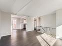 Spacious living room with hardwood flooring and an open layout leading into a bright kitchen with stainless appliances at 5153 Scranton St, Denver, CO 80239