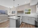 Bright kitchen with white cabinets, quartz countertops, stainless steel appliances, and stylish pendant lighting at 2140 S Ash St # 105, Denver, CO 80222