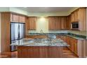 Well-equipped kitchen featuring wood cabinets, granite countertops, and stainless steel appliances at 14033 E Whitaker Dr, Aurora, CO 80015