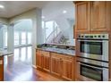 Gourmet kitchen featuring double ovens, granite countertops, and hardwood floors at 14033 E Whitaker Dr, Aurora, CO 80015