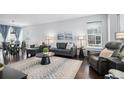 Bright living room featuring modern furniture, sleek hardwood floors, and a neutral color palette at 14693 E Crestridge Dr, Aurora, CO 80015