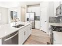 Kitchen island with stainless steel appliances, double sink, and white cabinets at 781 N Tempe St, Aurora, CO 80018