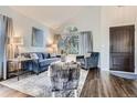 Bright living room with vaulted ceiling, large window, modern furnishings and hardwood flooring at 9523 Sherrelwood Ln, Highlands Ranch, CO 80126