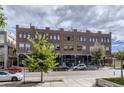 Modern brick building with visible rooftop access, street parking, and landscaping at 4144 Tennyson St # 212, Denver, CO 80212