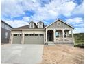 Inviting home showcasing a quaint covered porch, a two-car garage, and dormer windows for added charm at 3895 Buttongrass Trl, Castle Rock, CO 80108