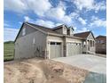 Exterior view of a house with a two-car garage, showcasing the side elevation and landscaping potential at 3895 Buttongrass Trl, Castle Rock, CO 80108