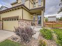 Inviting home exterior with stone accents, a cozy porch, and meticulous landscaping at 4862 S Piccadilly Ct, Aurora, CO 80015