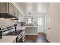Updated kitchen features stainless steel range, light grey cabinets, tile backsplash and hardwood floors at 8160 Washington St # 67, Denver, CO 80229