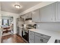 Updated kitchen features stainless steel refrigerator, range, grey cabinets and hardwood floors at 8160 Washington St # 67, Denver, CO 80229
