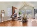 Bright living room with vaulted ceiling, brick fireplace, and large windows providing ample natural light at 8834 Blue Mountain Pl, Highlands Ranch, CO 80126