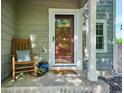 Inviting front porch with rocking chair, plants, and stylish decor at 1169 S Alton Ct, Denver, CO 80247