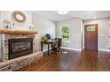 Cozy living room featuring a stone fireplace, hardwood floors, and a bright window at 1169 S Alton Ct, Denver, CO 80247