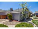 Well-maintained home with gray siding, stone chimney, neat landscaping, and a walkway at 12780 E Bethany Pl, Aurora, CO 80014