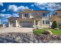 Stately two-story home with a three-car garage, manicured lawn, and stone landscape edging at 21229 E 50Th Ave, Denver, CO 80249