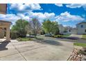Street view showcasing a well-maintained home with mature trees, a spacious driveway, and neighborhood charm at 21229 E 50Th Ave, Denver, CO 80249