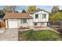 Charming two-story home with brick and white siding, a well-maintained lawn, and an attached garage at 1509 S Lewiston St, Aurora, CO 80017