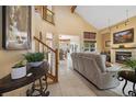 Open-concept living room featuring a vaulted ceiling, fireplace, and seamless access to the dining area at 3305 W 126Th Ave, Broomfield, CO 80020