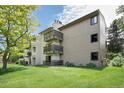Apartment building exterior with balconies, grassy lawn, and mature trees at 6505 Kalua Rd # 104B, Boulder, CO 80301