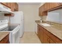 Functional kitchen featuring wood cabinets, white appliances, and granite countertops at 6505 Kalua Rd # 104B, Boulder, CO 80301